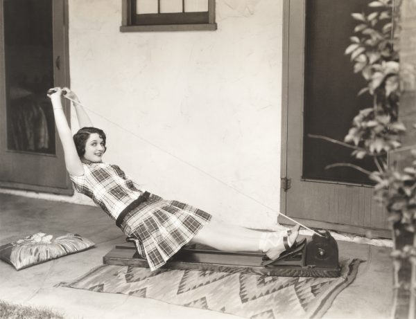 a woman rowing on an elastic cord rowing machine 