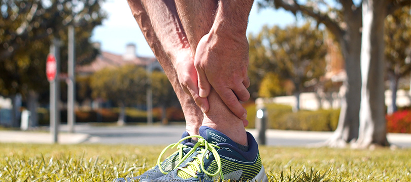 Hand on the calf and feet on the lawn