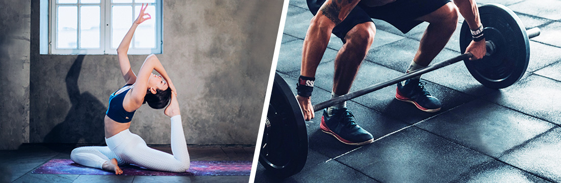 a woman practices yoga beside a wall and a man lifts up a barbell from the brick floor
