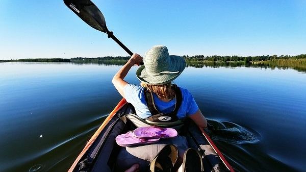 a woman kayaking on a blue lake