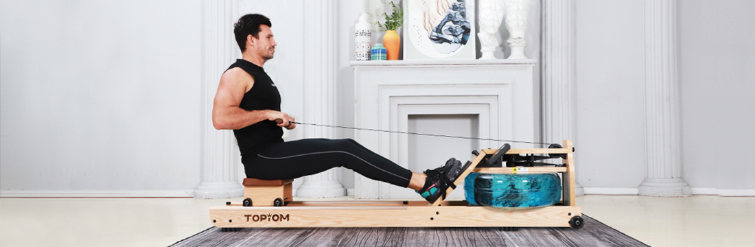 a man wearing black clothes rows with a rowing machine